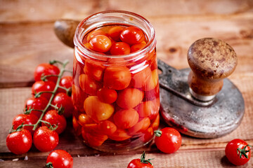 Pickled ripe tomatoes in a glass jar. 