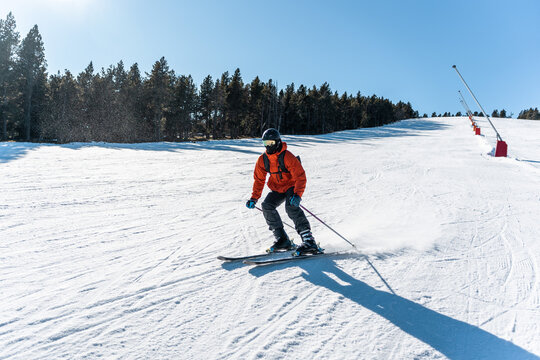 A boy skiing down a large ski slope.