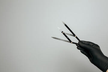 Beautician in gloves holding ruler for measuring brows