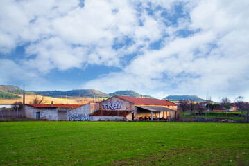 Beautiful landscape scenery with meadow and old farm house under cloudy sky Europe Spain