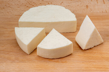 White italian fresh cheese called primo sale, sliced shape on wooden cutting board