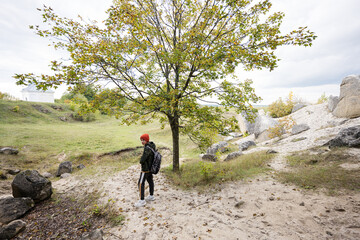 Fototapeta premium Boy wear backpack explore limestone stone cave at mountain in Pidkamin, Ukraine.