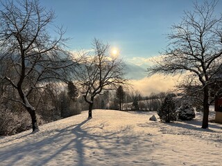 A magical play of sunlight and shadow during the alpine winter on the snowy slopes above the Lake Walen or Lake Walenstadt (Walensee), Amden - Canton of St. Gallen, Switzerland (Schweiz)