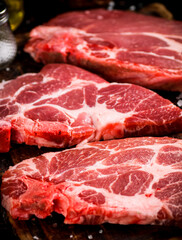 Raw pork steak on a wooden cutting board. 