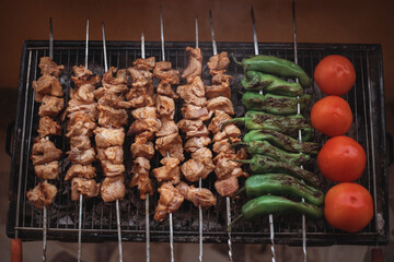 fried tomatoes peppers and garlic on the grill. Barbecue. Shish kebab and grilled peppers on hot...