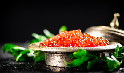 Full bowl of red caviar on the table. 