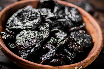 Prunes wooden plate on the table. 