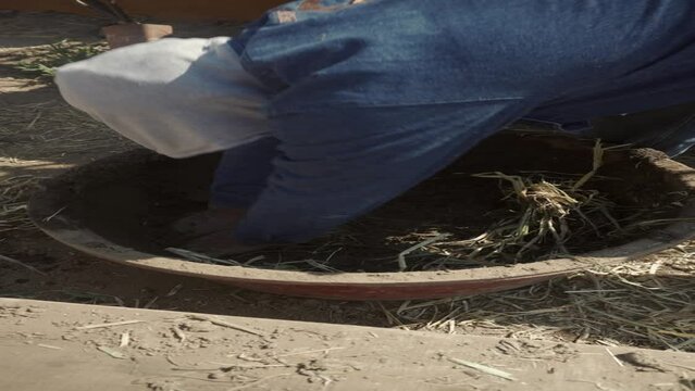 person mixing straw and earth for the technical construction of bioconstruction