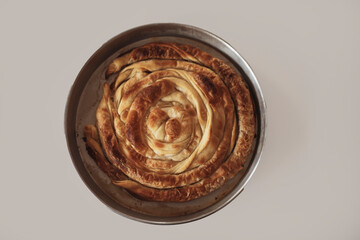 on a white background Turkish Tepsi Boregi, Round Borek, Tray pastry (Turkish name; rulo borek)