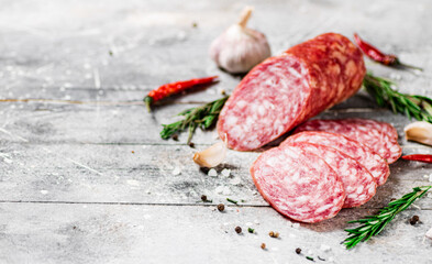 Pieces of salami sausage with spices, rosemary and chili peppers. 