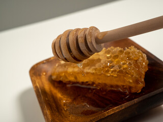 With honeycombs and a wooden spoon for honey in a wooden cup. Honeycombs and honey.