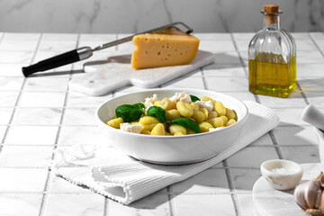 gnocchi with mozzarella and basil on a white background