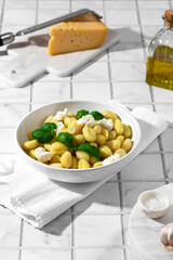 gnocchi with mozzarella and basil on a white background
