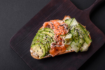 Fresh tasty sandwich with salmon, avocado and sesame and flax seeds