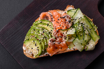 Fresh tasty sandwich with salmon, avocado and sesame and flax seeds