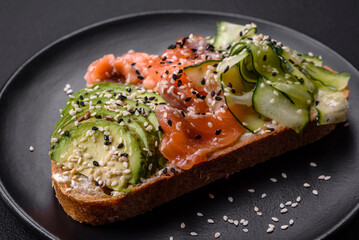 Fresh tasty sandwich with salmon, avocado and sesame and flax seeds