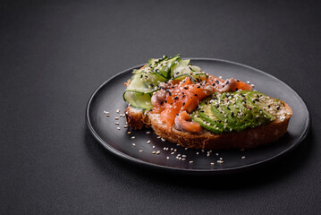 Fresh tasty sandwich with salmon, avocado and sesame and flax seeds