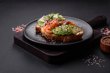 Fresh tasty sandwich with salmon, avocado and sesame and flax seeds