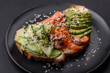 Fresh tasty sandwich with salmon, avocado and sesame and flax seeds