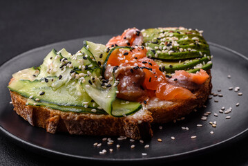 Fresh tasty sandwich with salmon, avocado and sesame and flax seeds