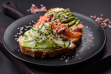 Fresh tasty sandwich with salmon, avocado and sesame and flax seeds