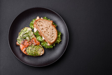 Fresh tasty sandwich with salmon, avocado and sesame and flax seeds
