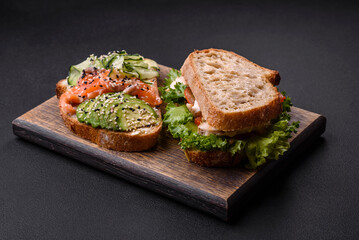 Fresh tasty sandwich with salmon, avocado and sesame and flax seeds