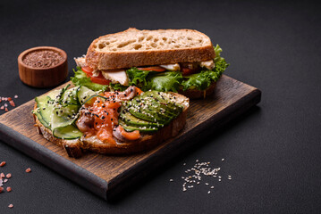 Fresh tasty sandwich with salmon, avocado and sesame and flax seeds