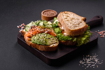 Fresh tasty sandwich with salmon, avocado and sesame and flax seeds