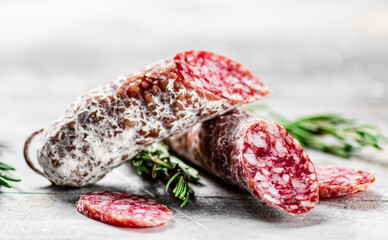 Pieces of salami sausage with sprigs of rosemary. 