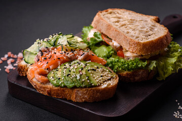 Fresh tasty sandwich with salmon, avocado and sesame and flax seeds