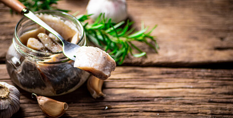 A piece of salted herring on a fork. 