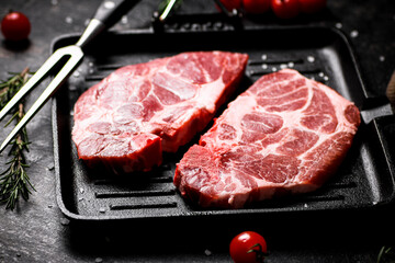 Raw pork steak in a frying pan. 