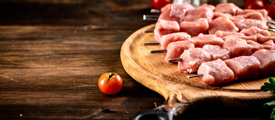 Pork kebab raw on skewers on a cutting board. 