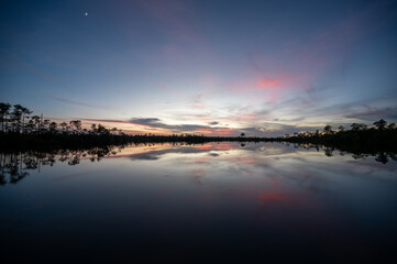 Colorful twilight cloudscape over and reflected in Pine Glades Lake in Everglades National Park, Florida..