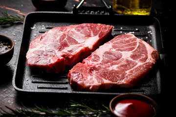 Raw pork steak on a grill pan. 