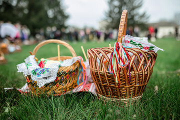 Easter baskets on the grass during the liturgy for Orthodox Easter. Consecration of Easter cakes and eggs with holy water