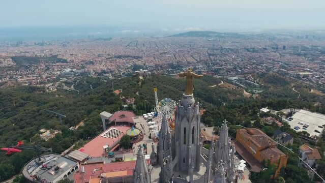 Fantastic overview aerial footage around the Expiatory Church of the Sacred Heart of Jesus (Temple Expiatori del Sagrat Cor) at the dawn in Tibidabo mountain in Barcelona.