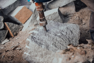 Fototapeta premium A stone pierces a factory worker. Heavy stone processing industry