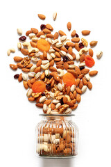 Dried fruits and nuts mixed and glass jar. Concept of the Jewish holiday Tu Bishvat on white background with copy space - obrazy, fototapety, plakaty
