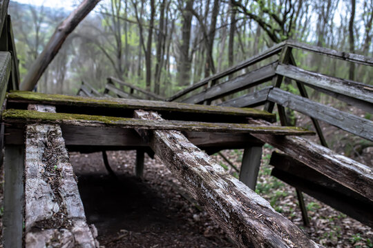 A big slump on the bridge. An old bridge with broken boards. Wooden emergency bridge overgrown with moss.