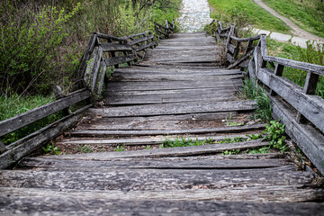 Fototapeta na wymiar Staircase of a wooden bridge. Wooden staircase from the mountain.