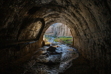 Exit from vaulted sewer tunnel. Underground river, view from inside of sewer tunnel