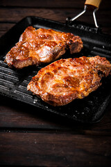 Grilled pork steak in a frying pan. 