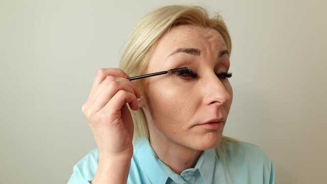 Closeup Of Beautiful Blond Woman Putting Black Mascara On Long Eyelashes With Brush. Beauty Cosmetics, Perfect Makeup, Fake Eyelashes Concept