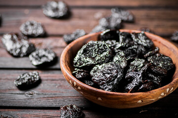 Prunes wooden plate on the table. 