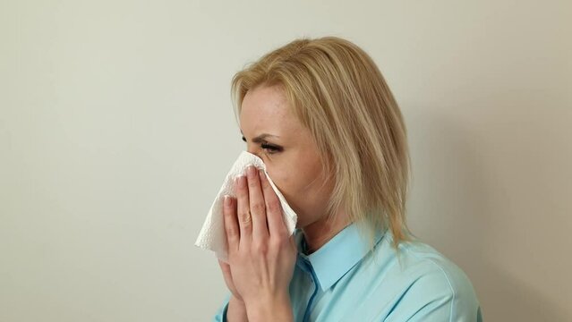 Woman blows her nose into a handkerchief. Allergy or illness symptom. Healthcare and medicine concept