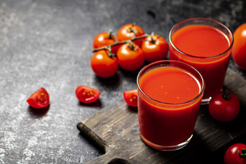 Tomato juice in a glass on a cutting board. 