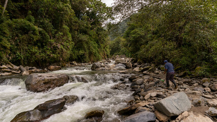 image of a river with plenty of water, large rocks and vegetation