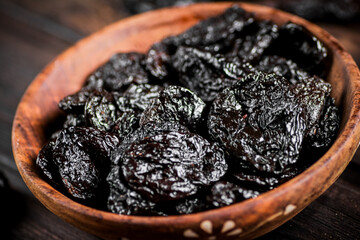 Prunes wooden plate on the table. 